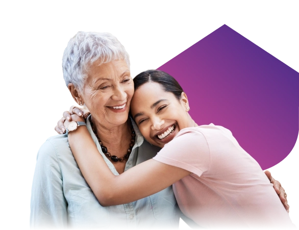 Smiling elderly woman with younger woman embracing