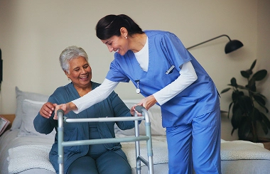 Nurse helping elderly woman with walker