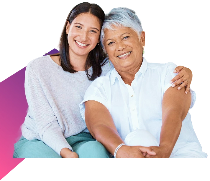 Smiling elderly woman with younger woman embracing