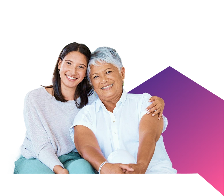 Smiling elderly woman with younger woman embracing