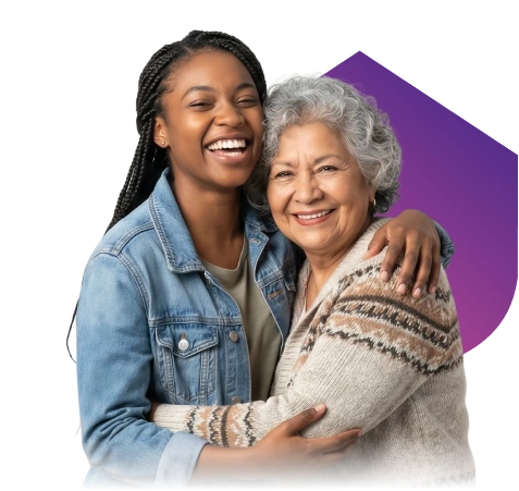 A young woman in a denim jacket and an elderly woman in a sweater warmly embrace, both smiling, against a black background with a purple shape.