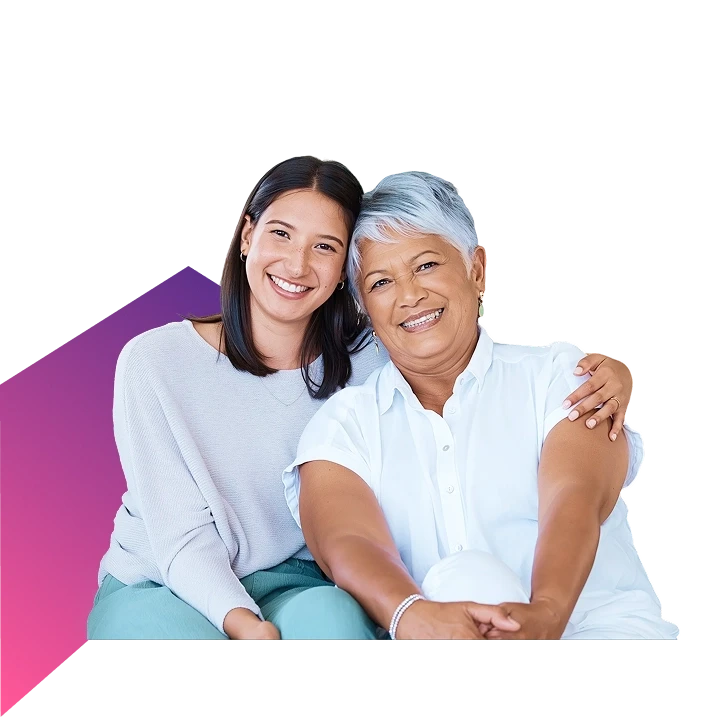 Young caregiver and senior woman smiling together against a white background